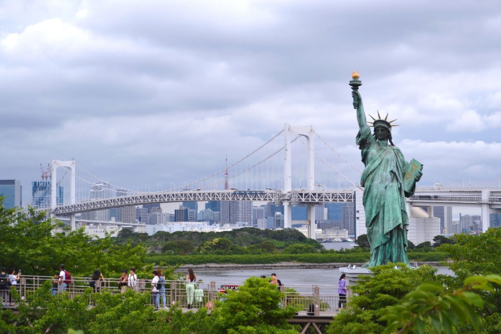 La statut de la liberté d'Odaiba, à l'arrière le Rainbow Bridge et la ville de Tokyo