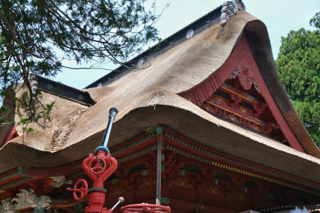 Une lance à incendie pour contrer un feu du toit de chaume du temple
