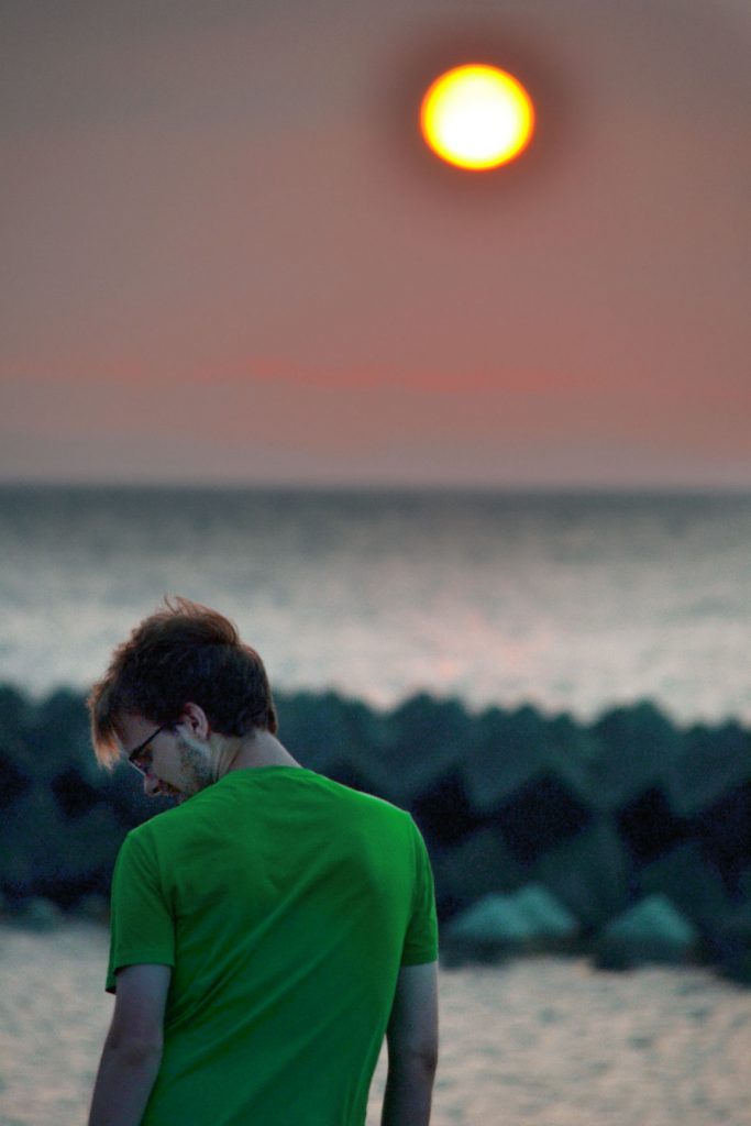 Vincent devant le coucher de soleil en bord de mer