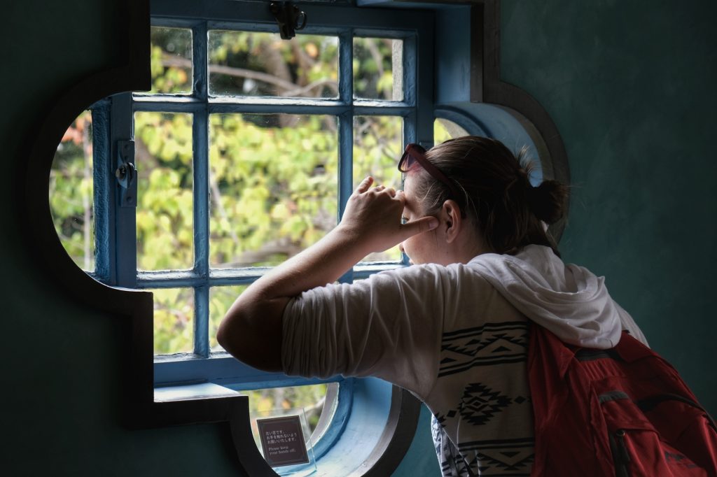 Claire regarde depuis la fenêtre du Berrick Hall à Yamate