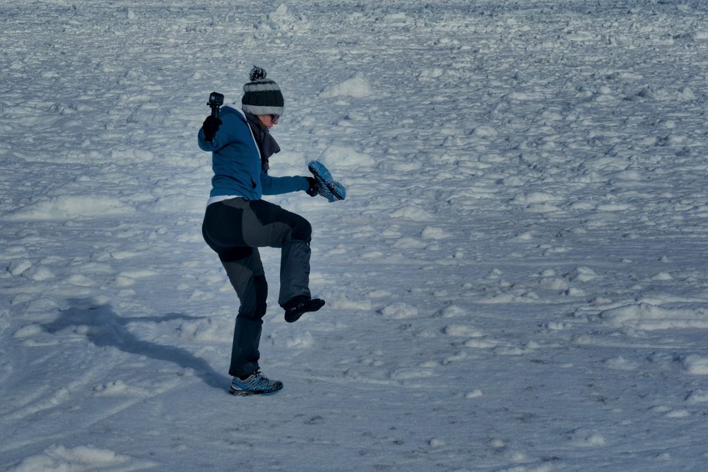 Claire enlève la neige de sa chaussure