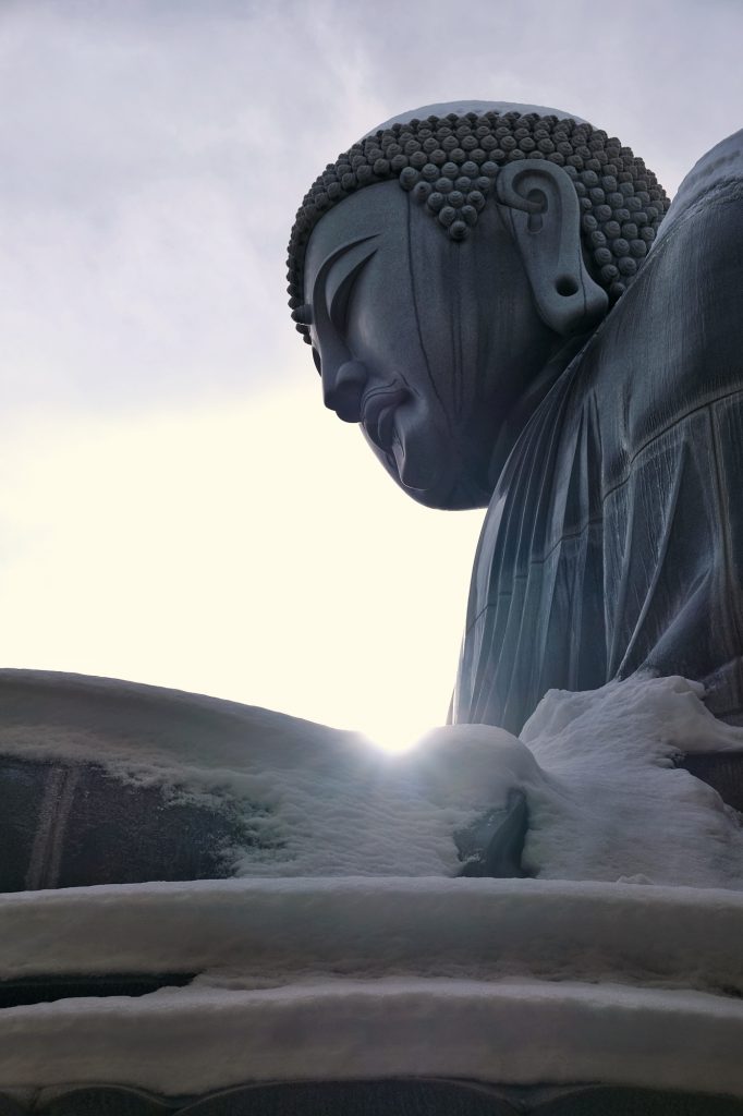Le soleil se lève derrière la statue de Bouddha