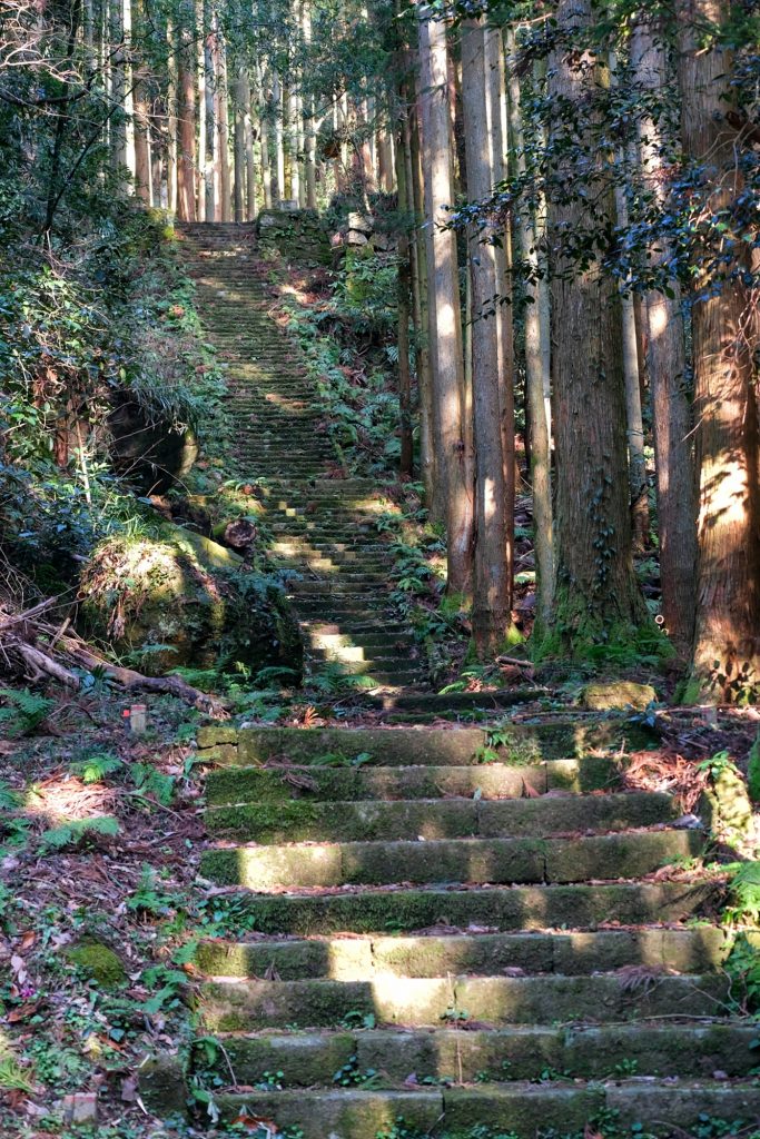 Des escaliers menant vers des ruines d'un temple dans la vallée d'Iwami Ginzan