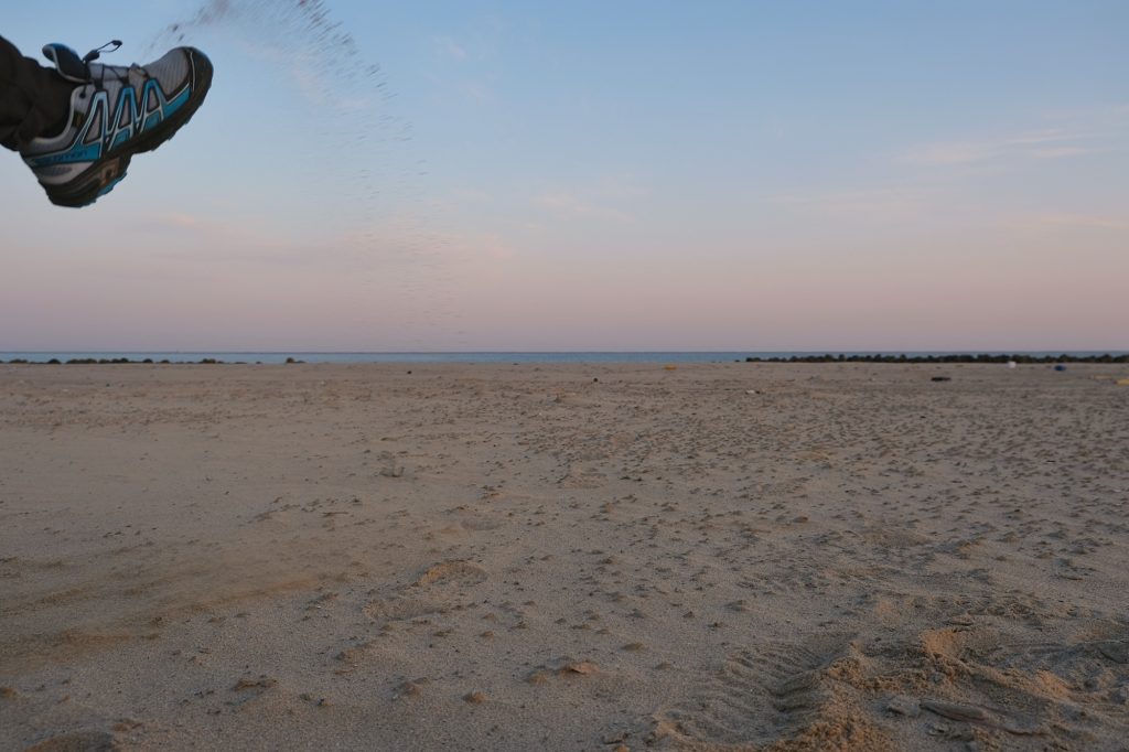 Un pied jette du sable devant l'objectif