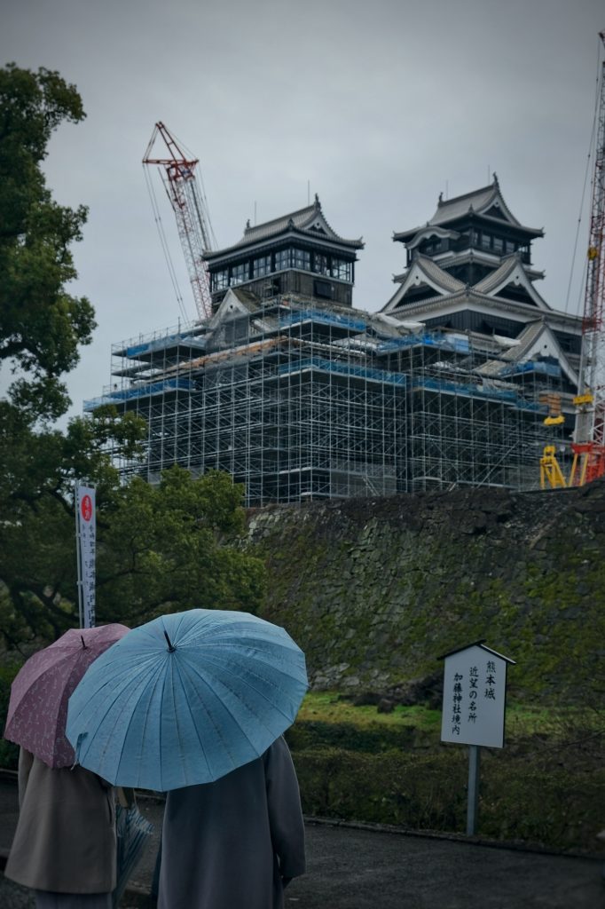 Les visiteurs contemplent (de loin) le château de Kumamoto en reconstruction suite au tremblement de terre de 2016