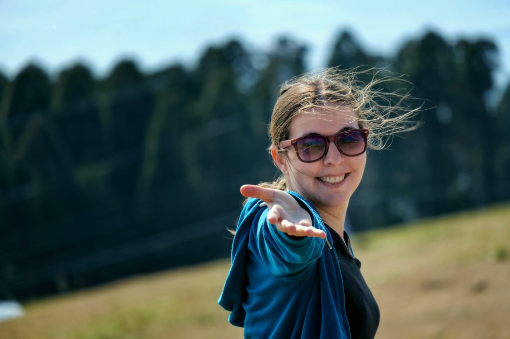 Claire, cheveux au vent et main tendue vers moi, au cap Toi