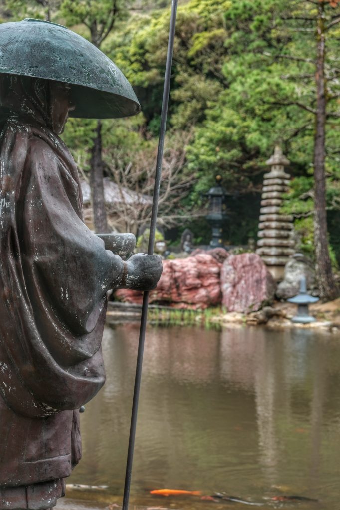 Statue de pèlerin au bord de l'étang du Kongofukuji