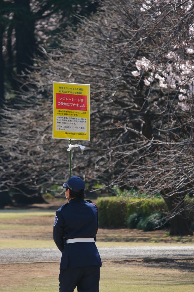 Surveillant pour empêcher les gens de se poser sur les pelouses du Shinjuku Gyoen