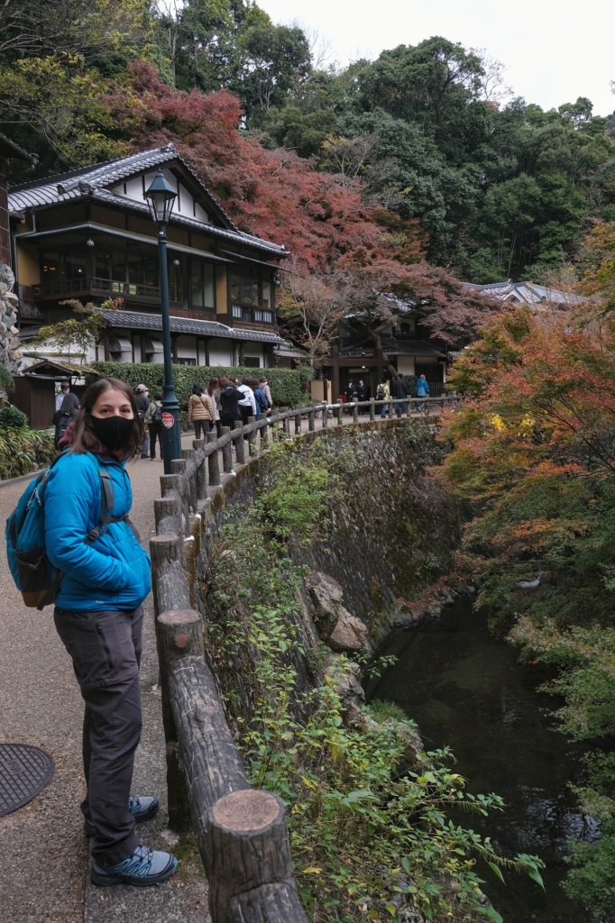 Claire, masquée, devant la rivière Minoo et les arbres colorés