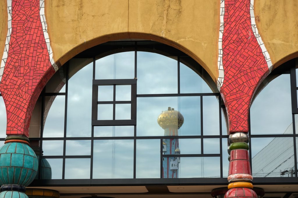 Reflet de la tour de l'usine d'incinération dans les vitres du centre de traitement des eaux usées de l'île de Maishima à Osaka