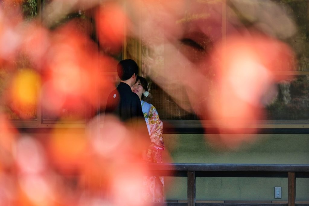 Un couple se fait prendre en photo devant la maison du jardin japonais de Daisen Sakai