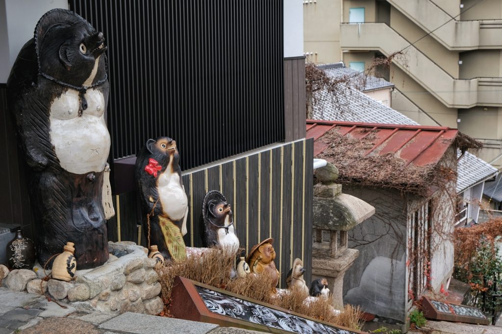 Une rangée de Tanuki dans des escaliers de Arima Onsen