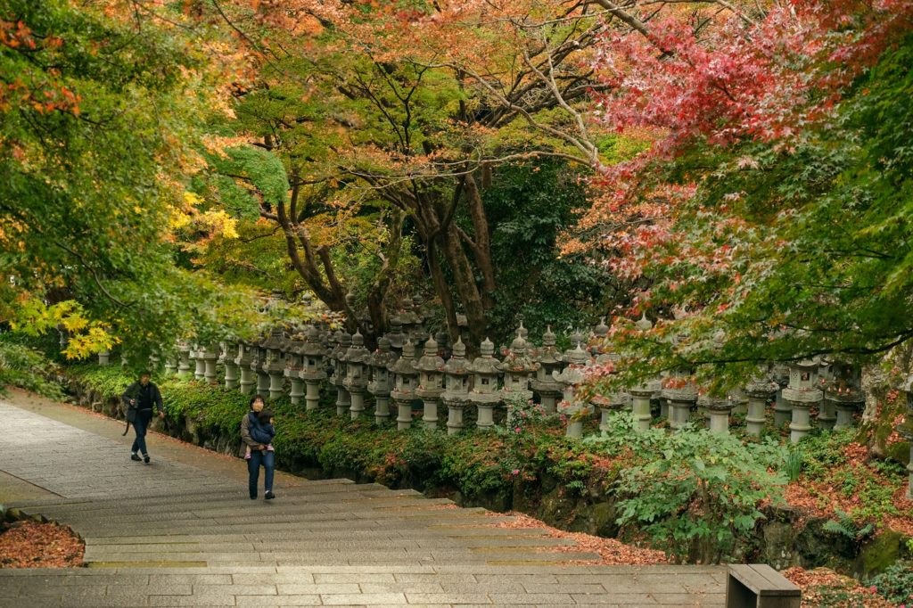 Des visiteurs avancent le long de l'allée principale du temple Katsuo-ji à Minoo